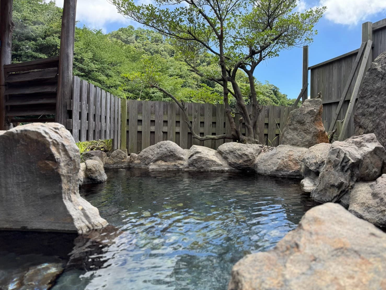木々の光が差し込む露天風呂